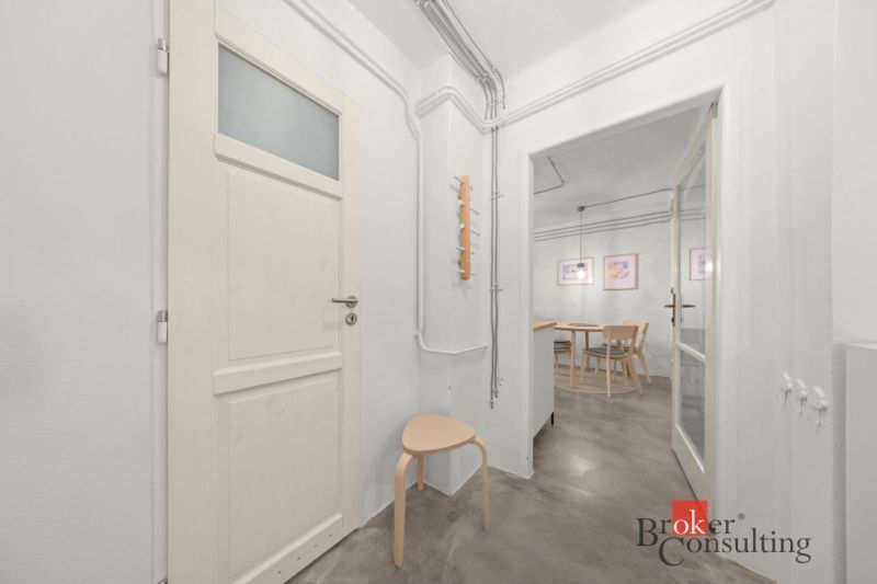 A bright hallway in a 2-room apartment with wooden furniture and a chair.