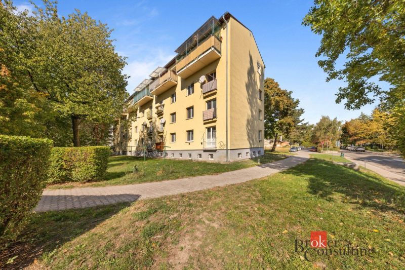 Apartment building on Hubeného Street in Bratislava-Rača surrounded by greenery and a road.