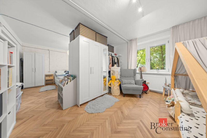Children's room in a two-room apartment with an open space and a wooden decor floor.