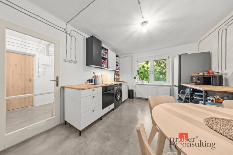 A kitchen in a 2-room apartment with a wooden decor floor and a spacious table.