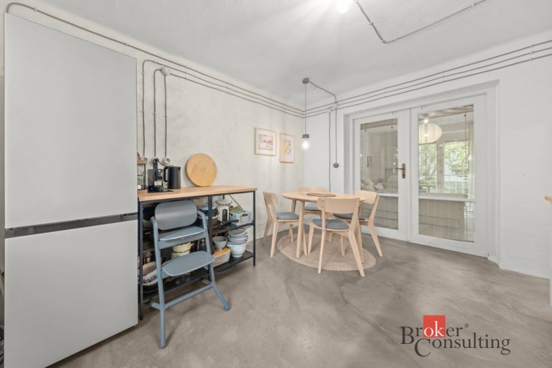 Dining room with a round table and glass doors in a two-room apartment.