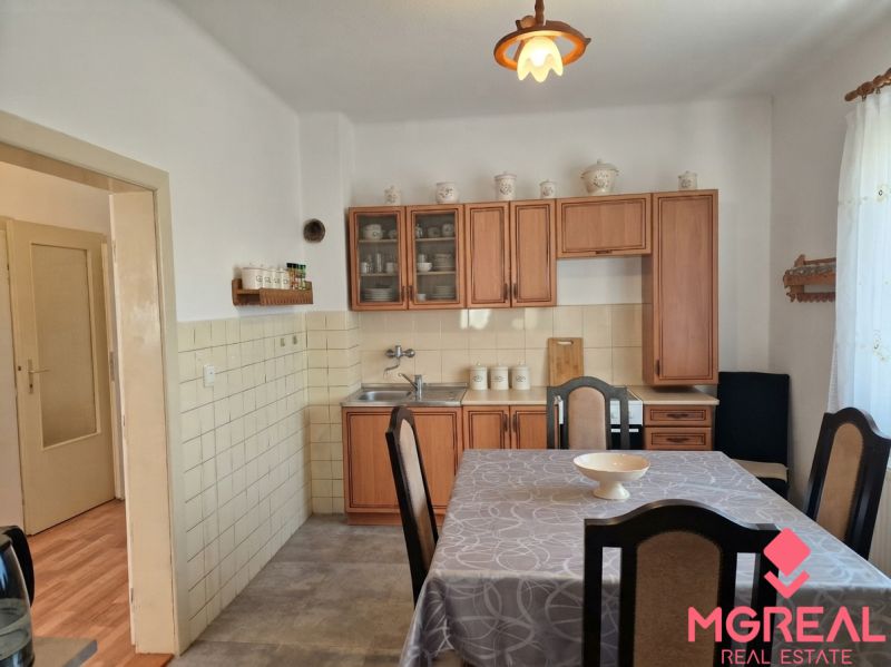 Kitchen in a family house with wooden decor, dining table, and rustic cabinets.