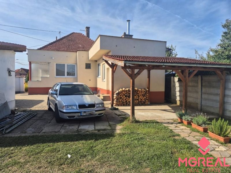Family house in Ludanice, car in the yard, wood under the shelter, garden.