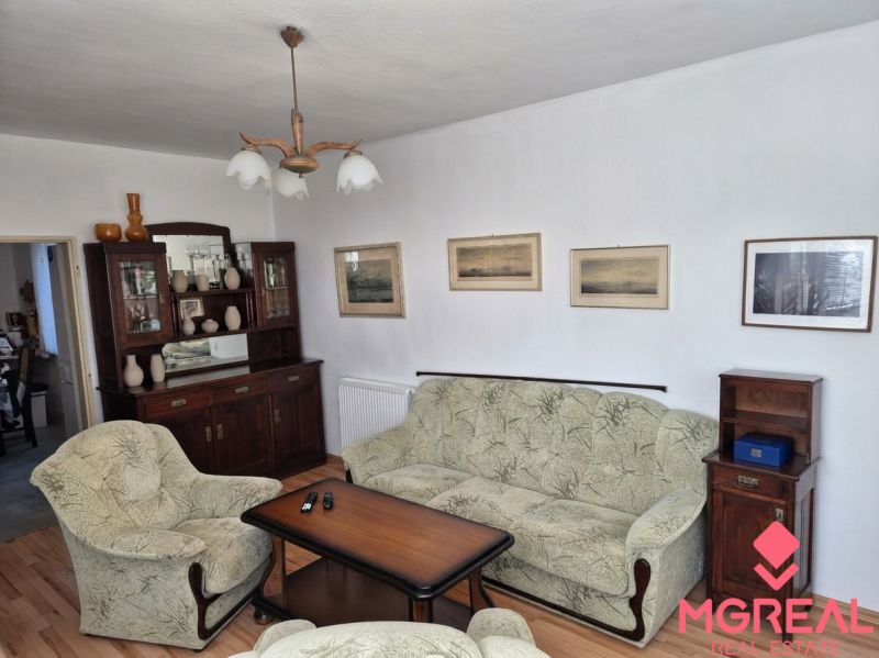Living room of a family house with armchairs, a sofa, and a furniture set.