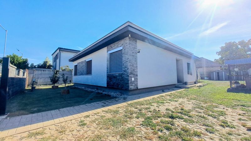 A family house in Horné Saliby with stone details and a landscaped garden.