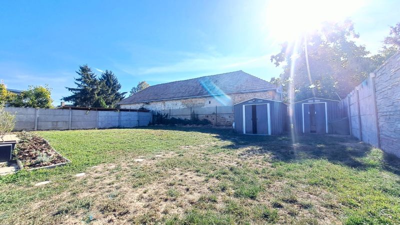 The garden of a family house in Horné Saliby with a lawn and metal shelters.