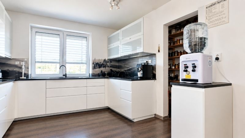 A kitchen in a family house with white cabinets and a wood-patterned floor.