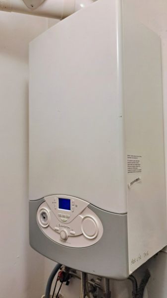 Gas boiler in a family house with a digital display and a white panel.