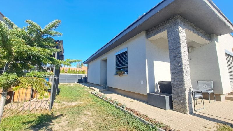 A family house in Horné Saliby with a terrace, greenery, and wooden decor on the cladding.