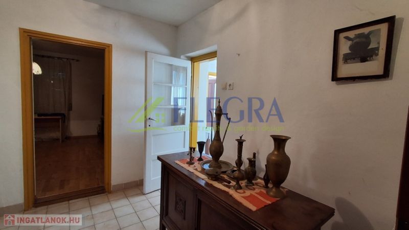Entrance hall in a family house with decorative furniture and wood-patterned flooring.