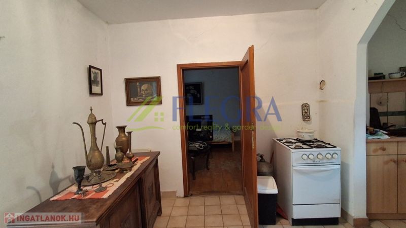 A kitchen with a gas stove in a family house, decorative vases on a sideboard.