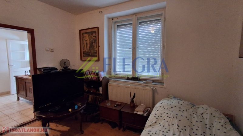 A room in a family house with a bed, a television, and a dresser.