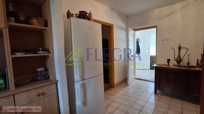 A kitchen in a family house with a white refrigerator and wooden furniture.