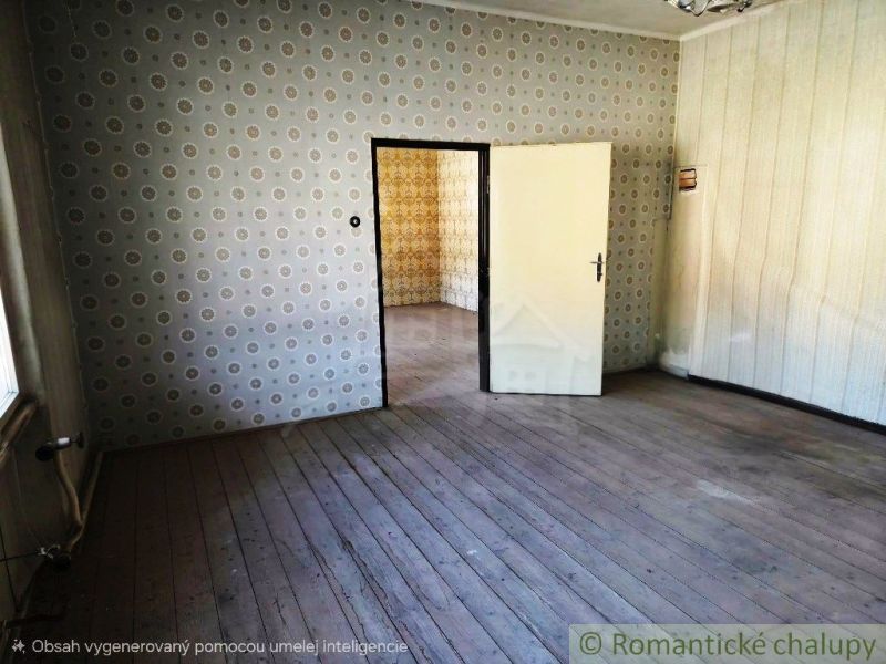 A room with wallpaper and wood-patterned flooring, with another room in the background.