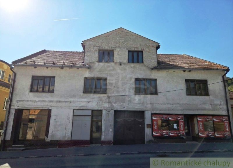 Commercial premises in Modrý Kameň with a worn facade and a sloped roof.