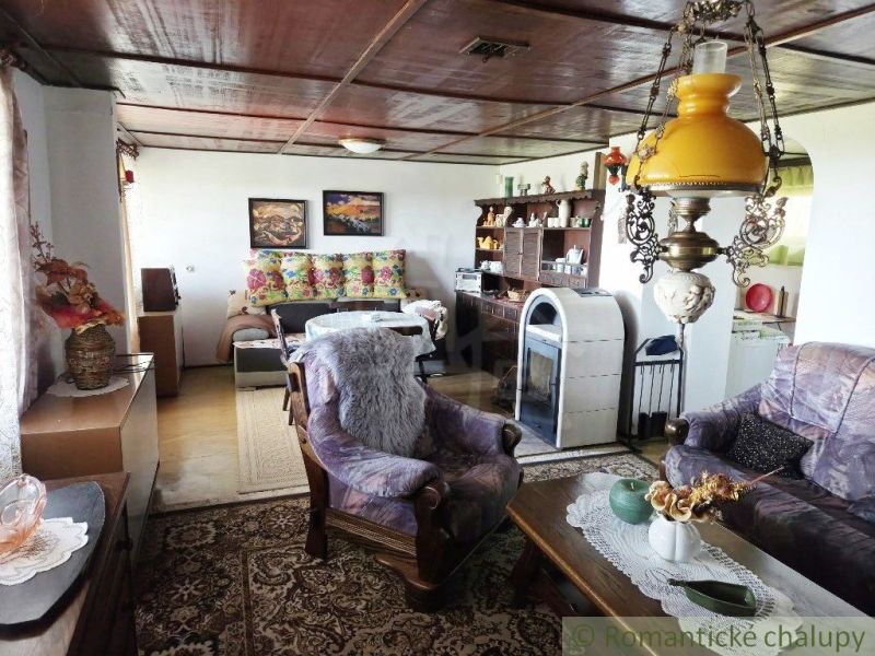 The interior of the cottage with decorative lamps, a sofa, rugs, and decorative furniture.