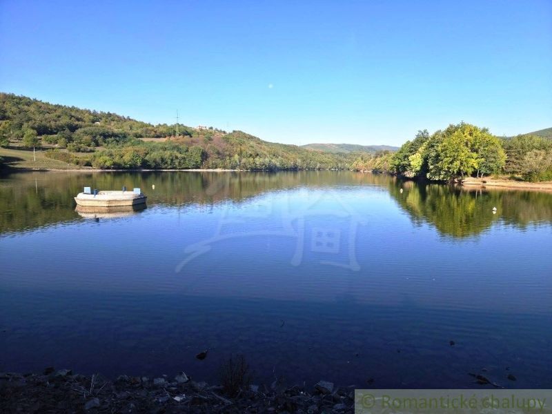 A picturesque view of a lake surrounded by greenery in the Gardens near Krupina.