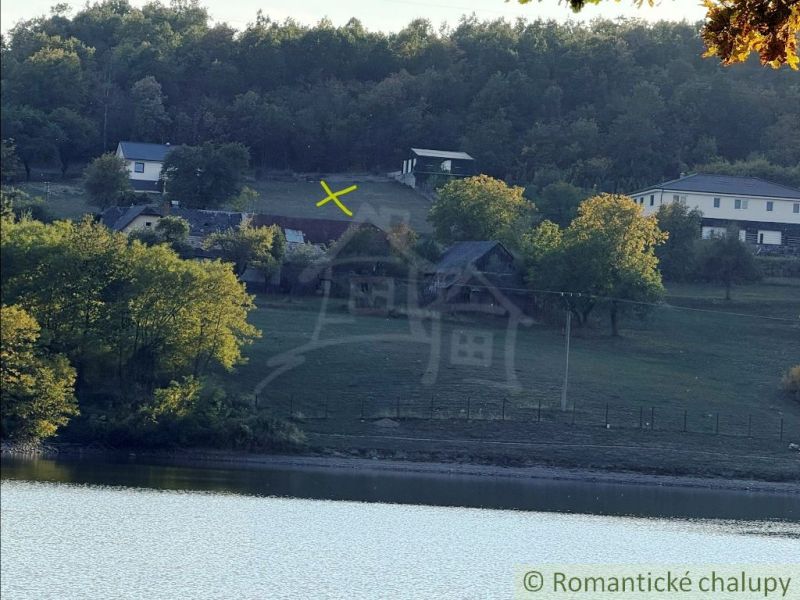 A view of the rural landscape and lake around Krupina with gardens and houses.