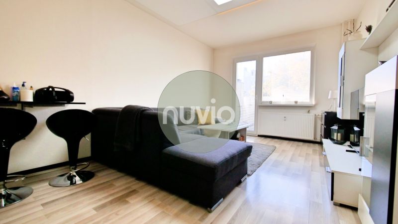 Living room in a two-room apartment with a wooden-decor floor and a comfortable sofa.