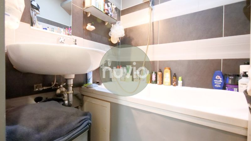 A bathroom in a 2-room apartment with a sink and a bathtub, utilizing storage space for cosmetics.